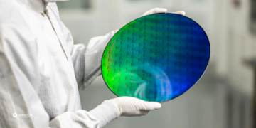 Researcher holding a PsiQuantum photonic wafer designed for next-generation quantum computing systems