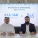 epresentatives of JAR Accounting & Auditing and Kifal sign a memorandum of understanding at a ceremony table, with both companies’ logos displayed on a screen behind them